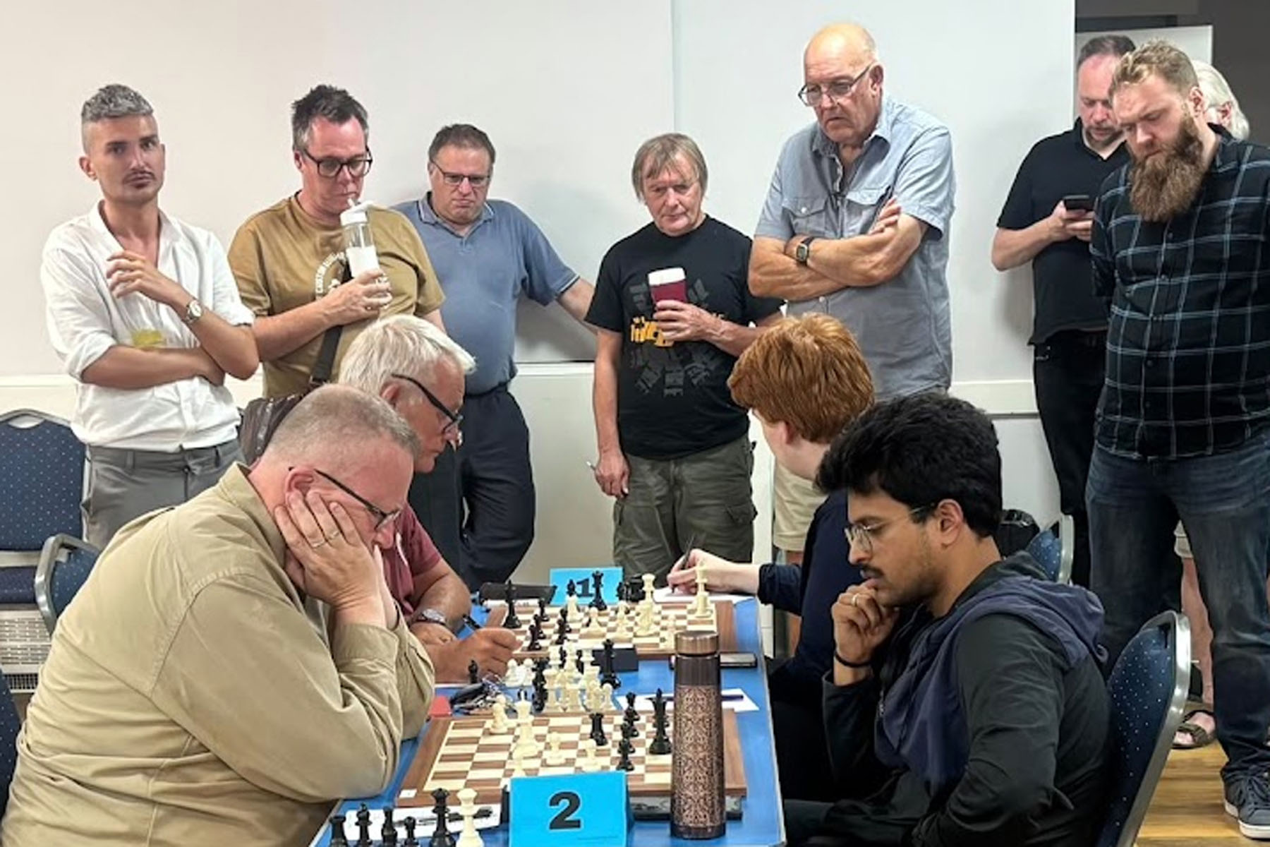 Spectators study the games on top boards